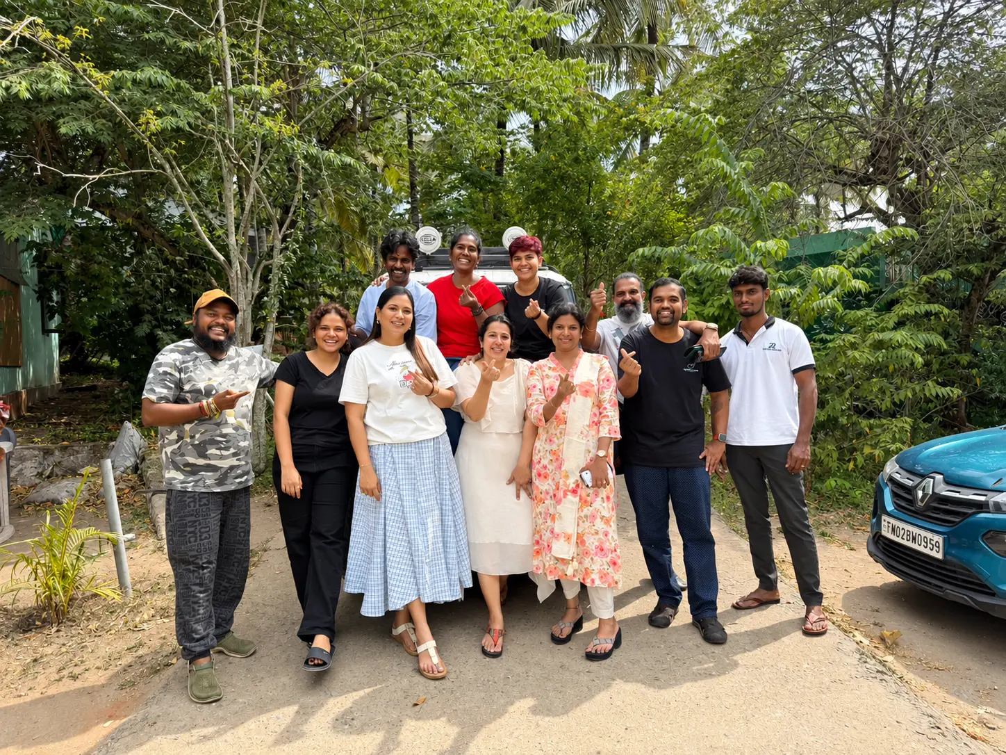 A small group of retreat participants with Dr. Indhu Nagaiah, smiling together under green trees